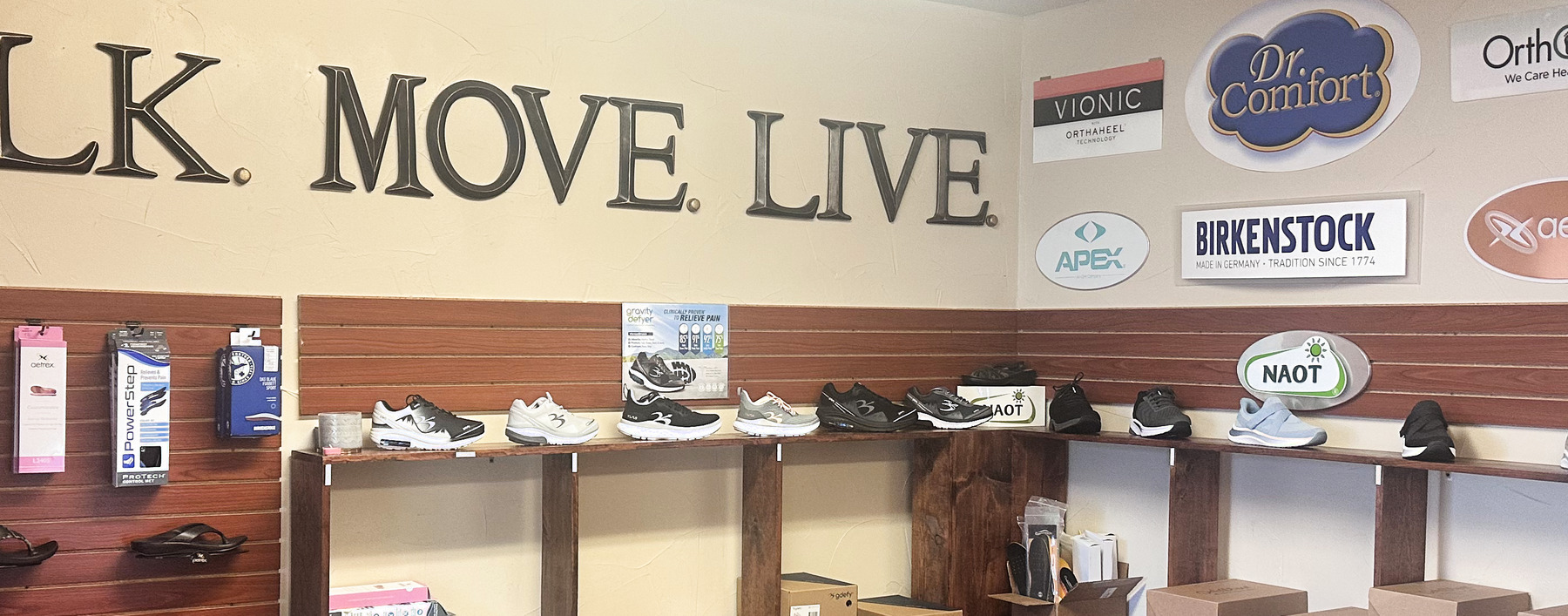 Walk. Move. Live. wall above the curated shoe display at Footsmart RX